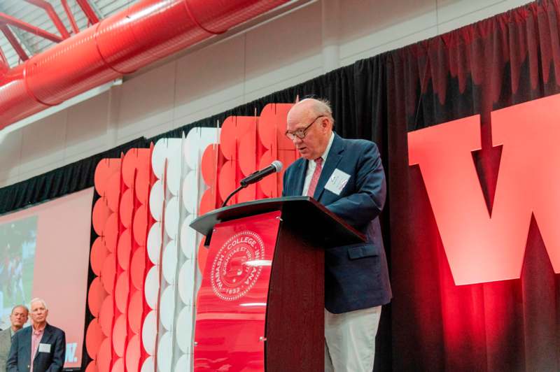 a man standing at a podium with a microphone