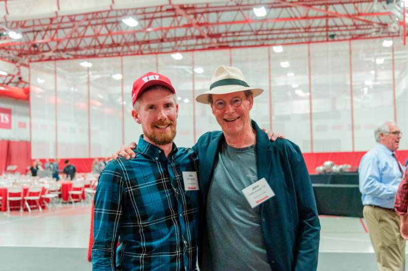 two men standing together smiling