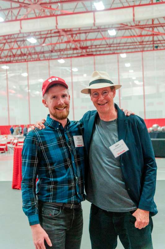 two men standing together smiling