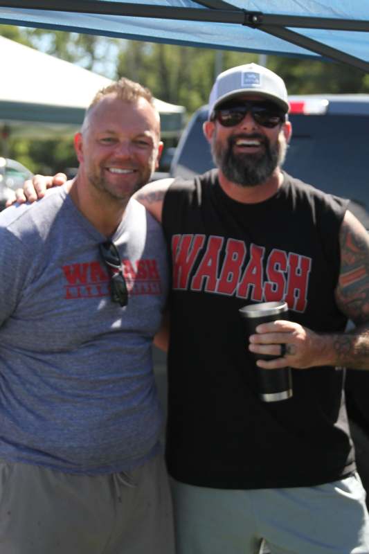 two men standing together smiling