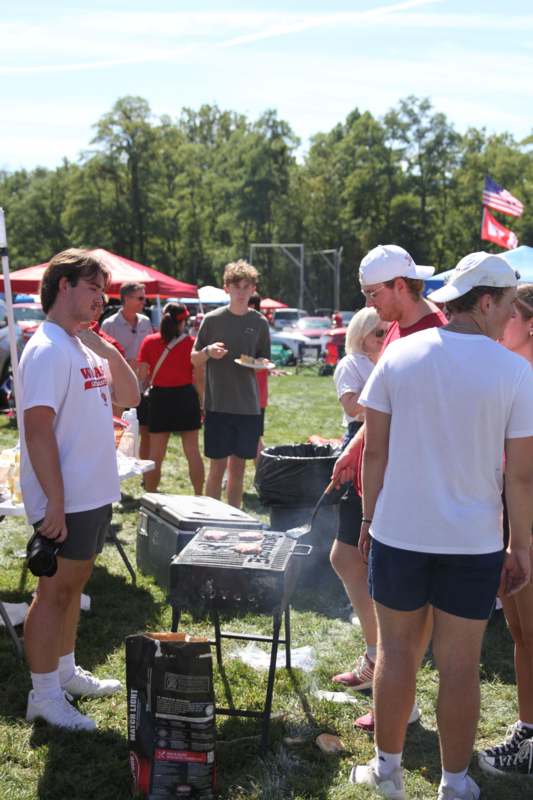 a group of people standing around a grill