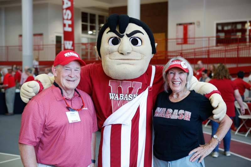 a man and woman posing with a mascot