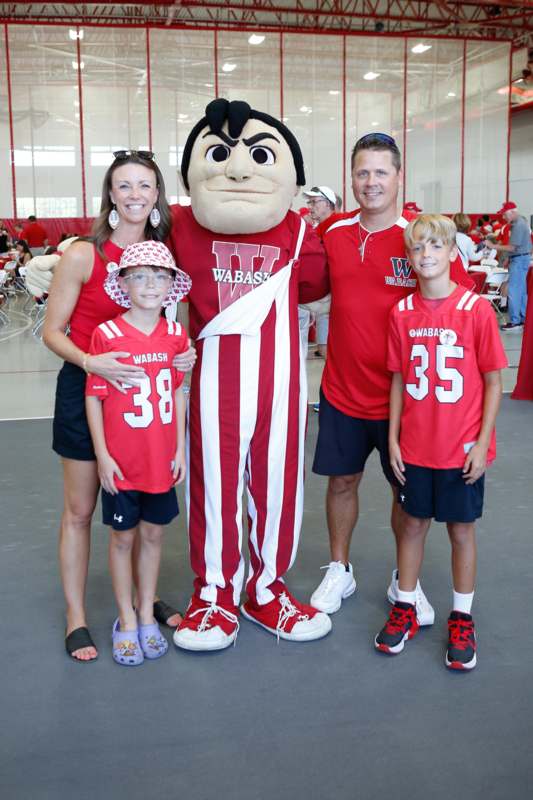 a group of people posing for a photo with a mascot