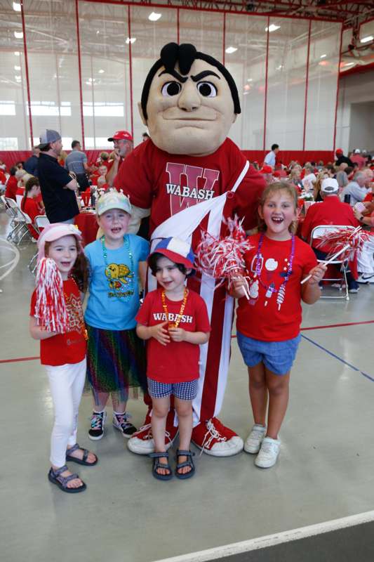 a group of kids posing for a photo with a mascot