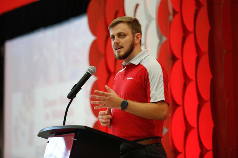 a man standing at a podium with a microphone