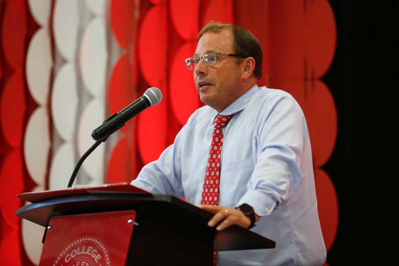 a man standing at a podium with a microphone