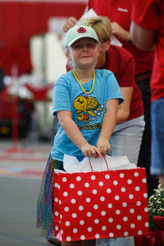 a girl holding a red and white polka dot bag