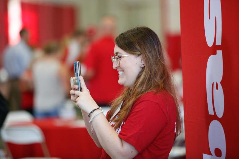 a woman smiling while holding a phone