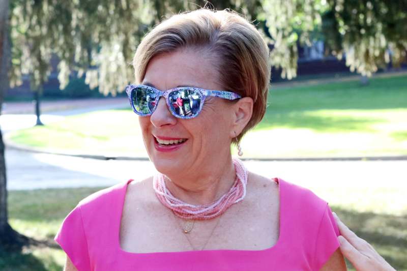 a woman wearing sunglasses and a pink dress