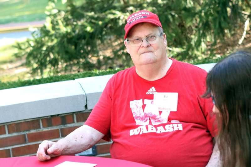 a man in a red shirt sitting at a table