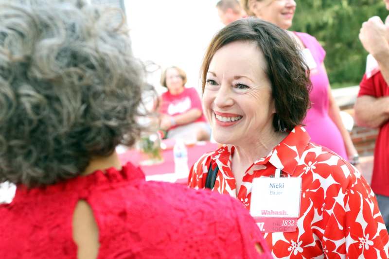 a woman in a red shirt talking to another woman