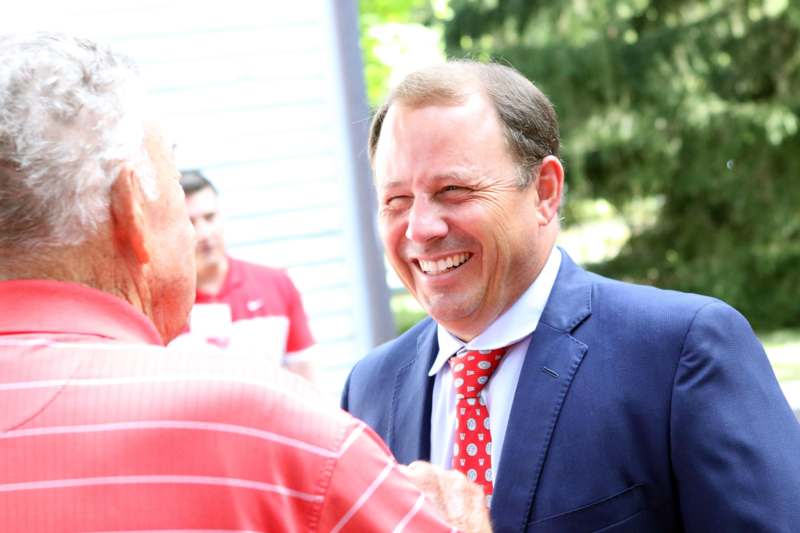 a man in a suit and tie laughing