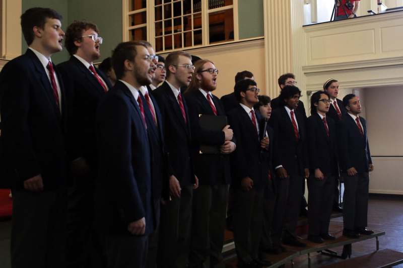 a group of men singing in a row