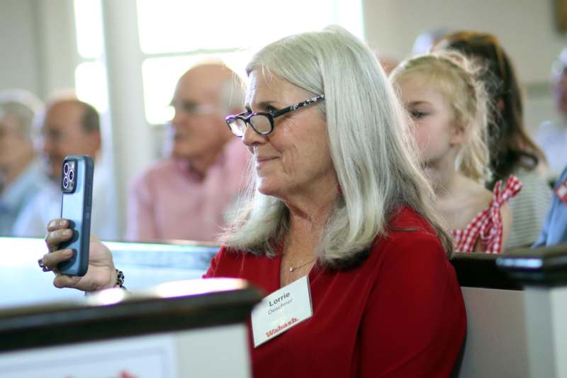 a woman wearing glasses and a name tag