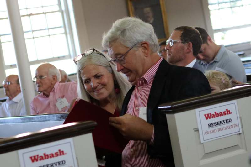 a man and woman looking at a red paper