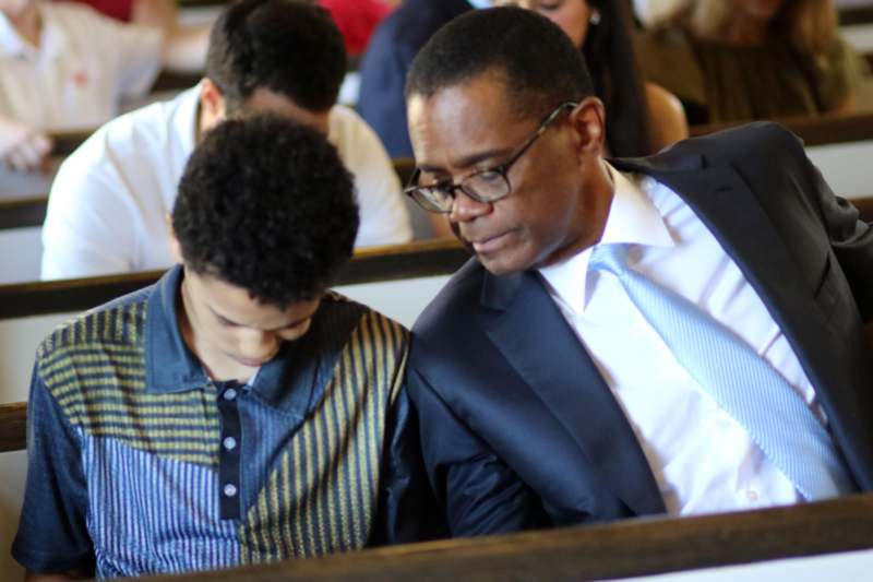 a man and boy sitting in a church