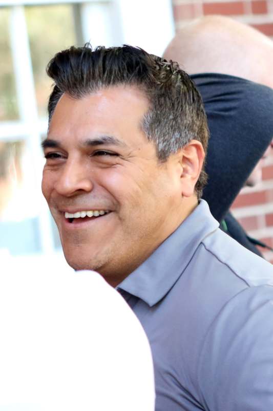 a man smiling with a grey shirt