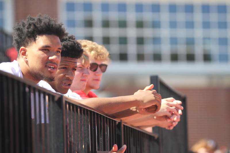 a group of men leaning on a railing