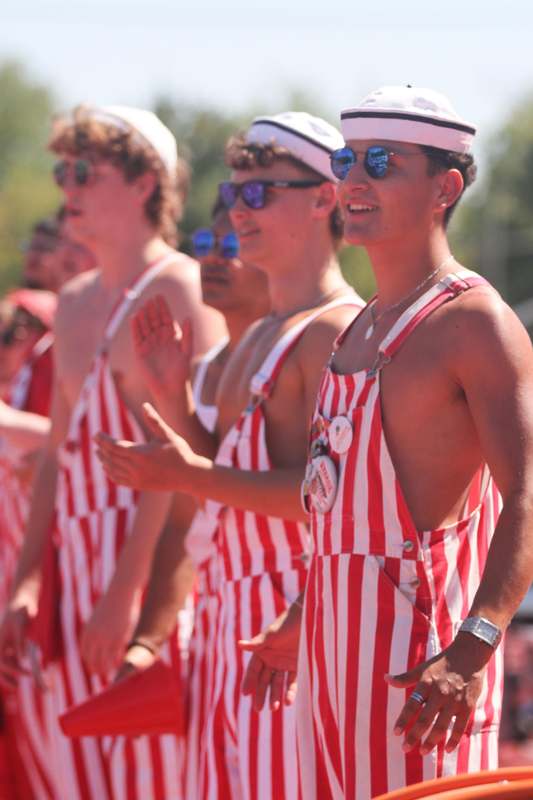 a group of men wearing red and white striped overalls