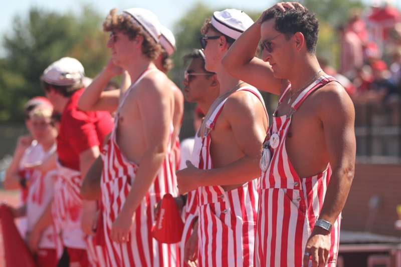 a group of men wearing red and white striped overalls