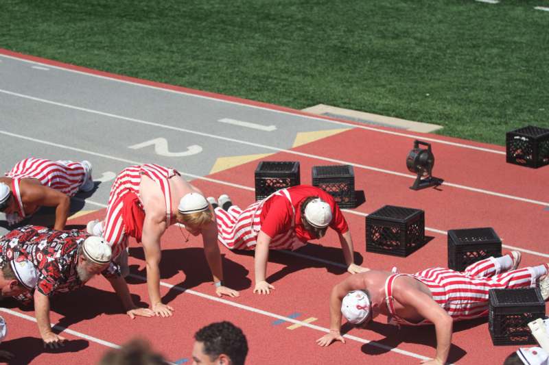 a group of men in red and white striped shirts on a track