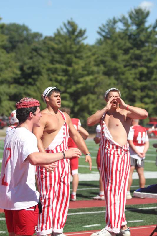 a group of men in striped overalls on a football field