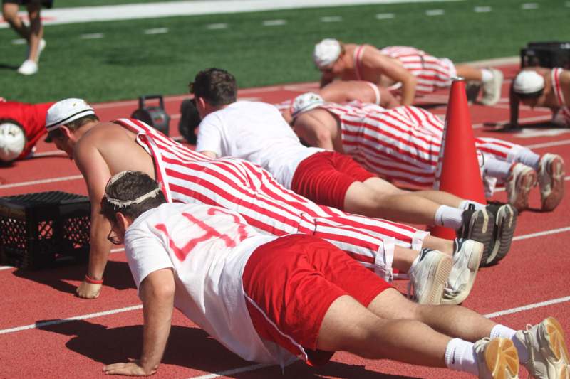 a group of people doing push ups on a track