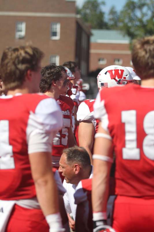 a group of football players in red and white uniforms