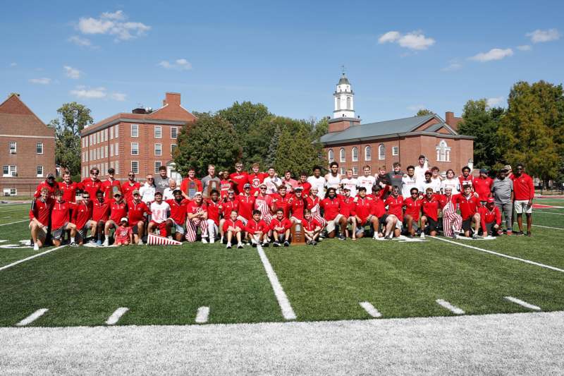 a group of people posing for a photo on a football field