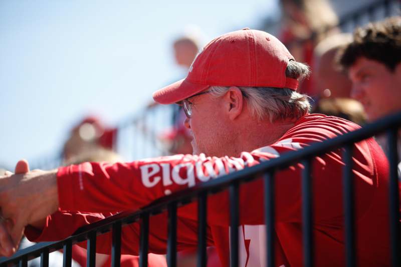 a man in a red hat leaning on a railing