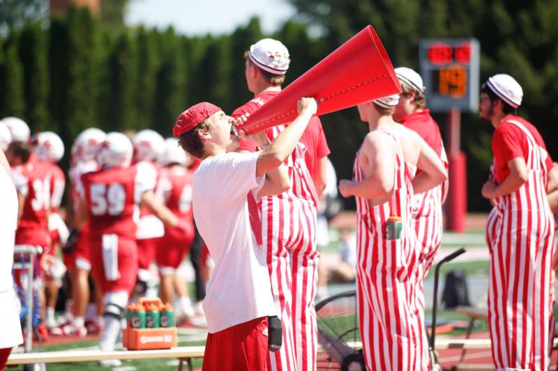 a man in striped pants speaking into a megaphone