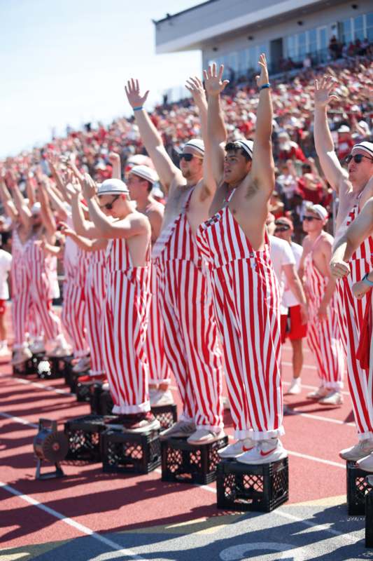 a group of people wearing striped overalls on a track