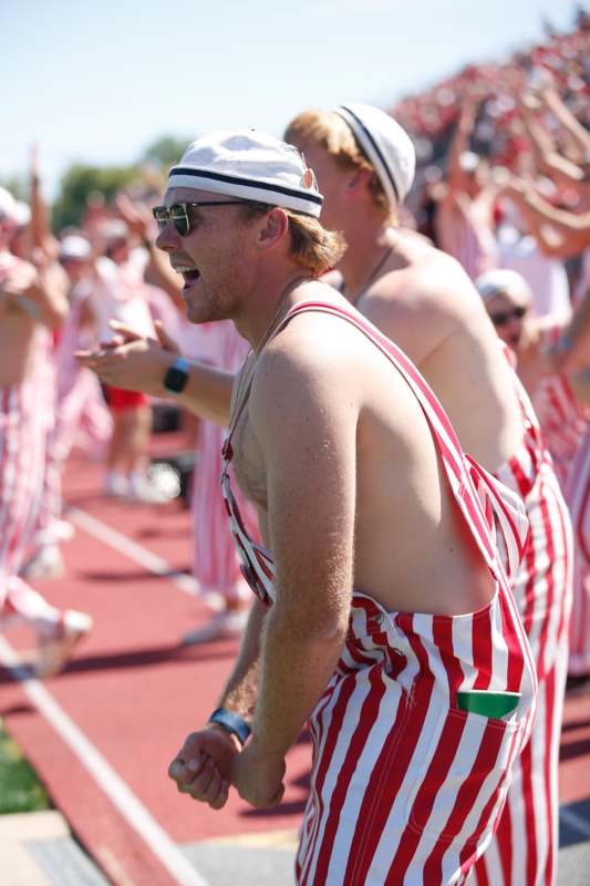 a group of men in striped overalls on a track