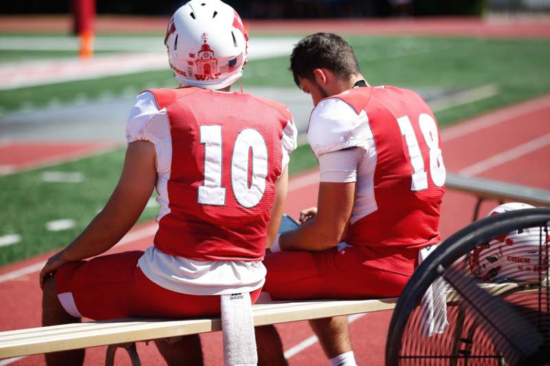 two football players sitting on a bench