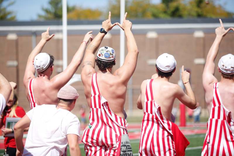 a group of men wearing striped overalls and hats