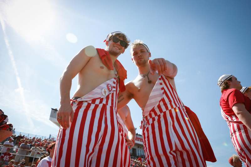 two men wearing striped pants and red capes