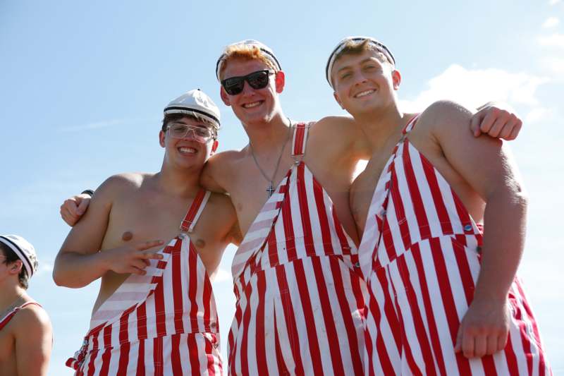 a group of men wearing striped overalls and sunglasses