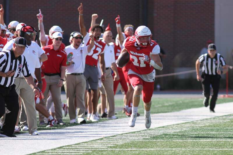 a football player running with a football in the air