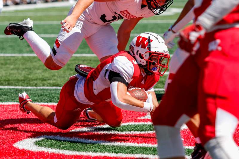 a football player diving for a ball