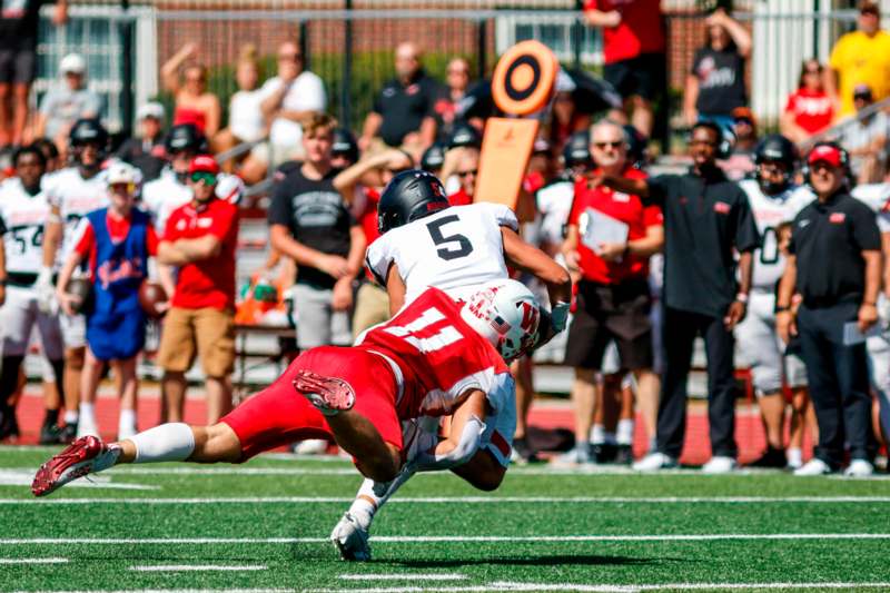 a football player falling down to another player