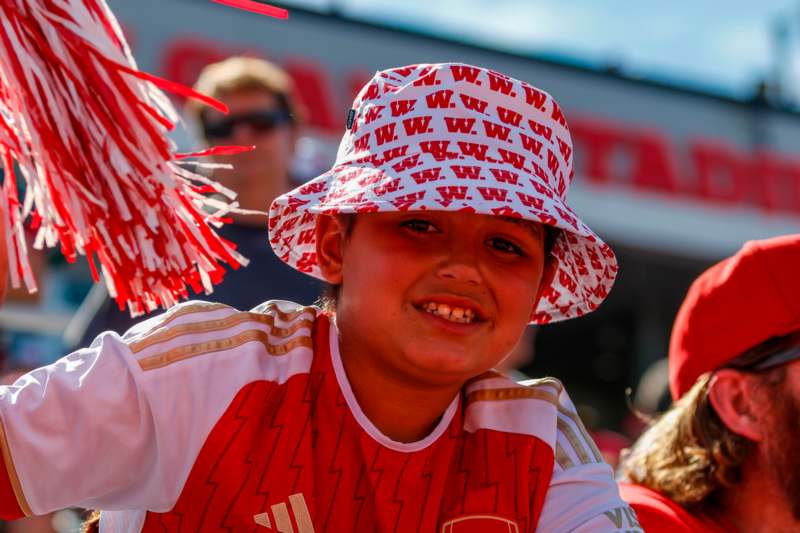 a boy wearing a hat and pom poms