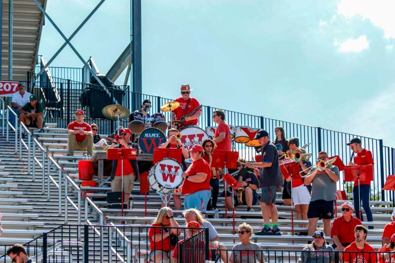 a group of people playing instruments on bleachers