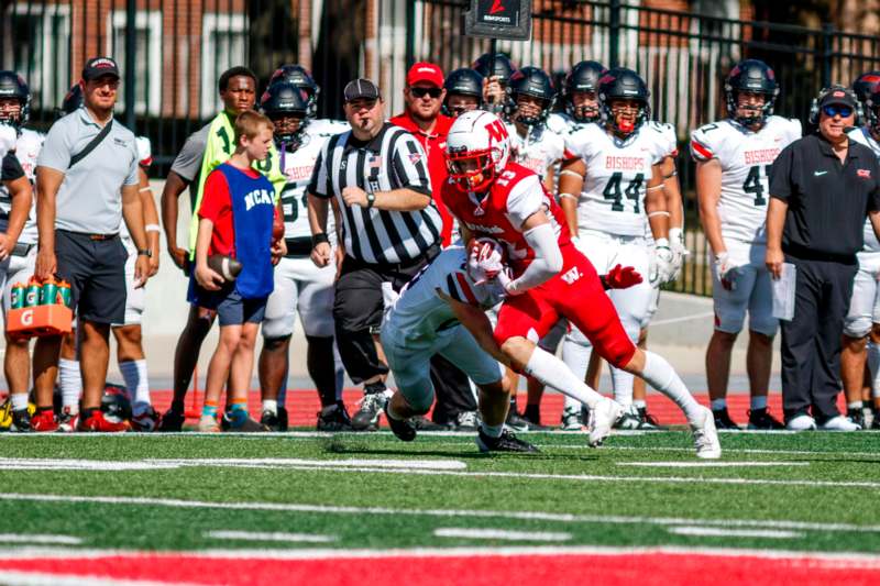 a football player running with a group of people behind him