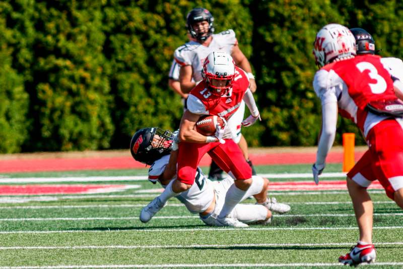 a football player in red and white uniform running with a football