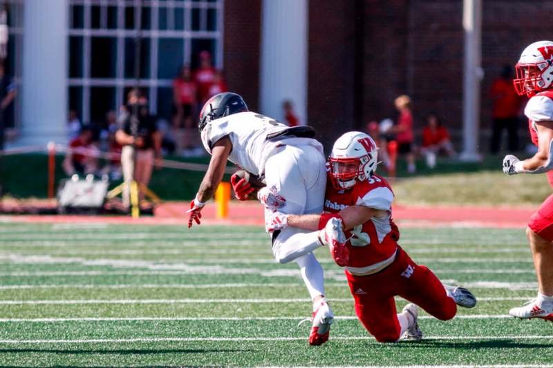 a football player running with another football player