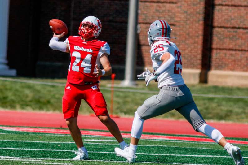 a football player in a red uniform with a football in the air