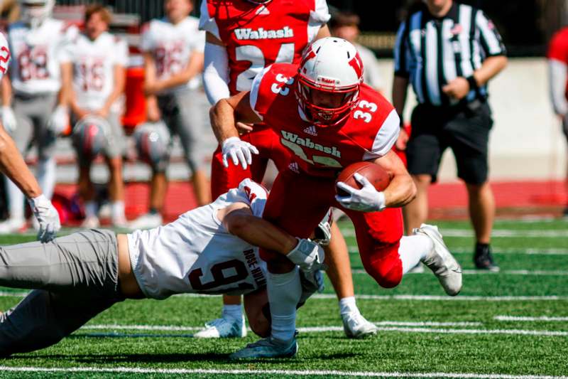 a football player in red uniform running with another player in the background