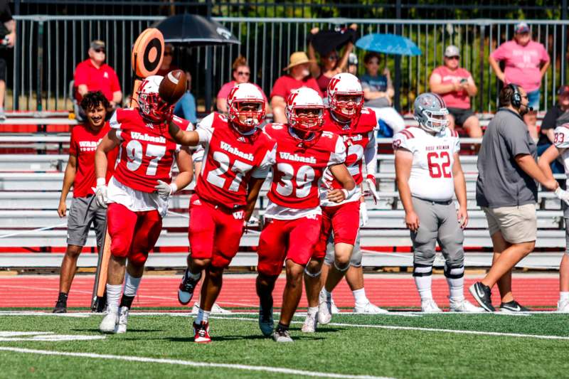 a group of football players running on a field