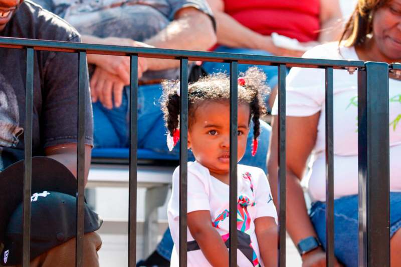 a child standing behind a metal fence