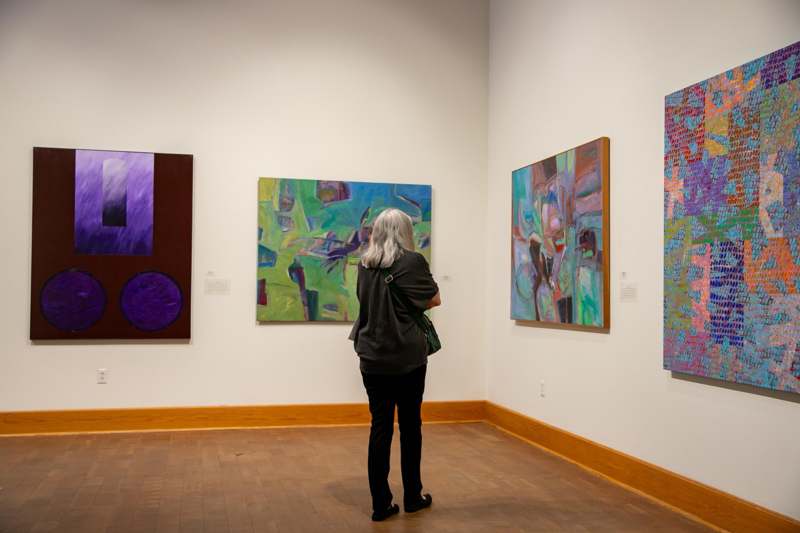 a woman looking at art on the wall